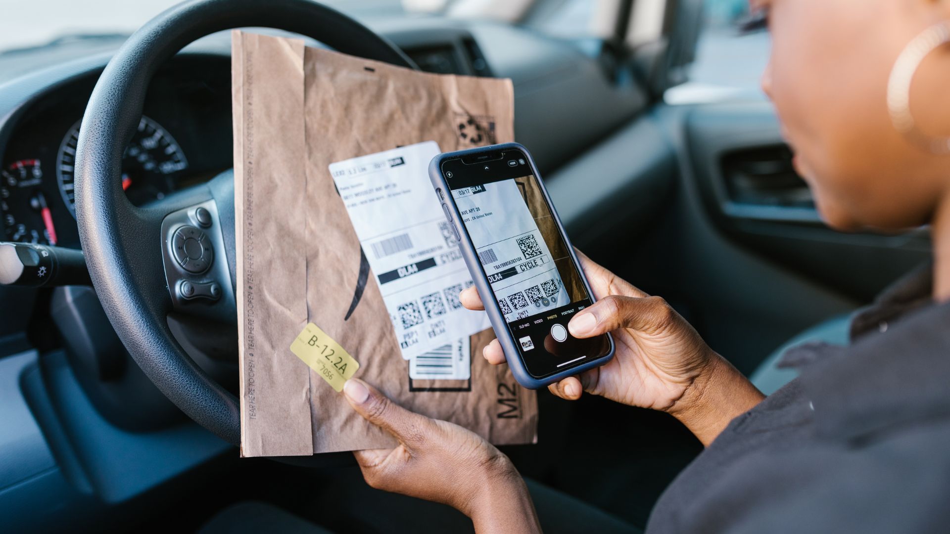 Delivery driver scanning package label inside vehicle using smartphone